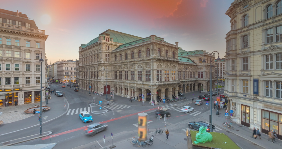 Beautiful view of Wiener Staatsoper (Vienna State Opera) time lapse day to night transition timelapse in Vienna, Austria. Illuminated historic buildings and traffic on streets Royalty-Free Stock Footage #1096790823