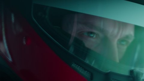 ECU Portrait of sports car driver in protective helmet racing on a speedway. Fast speed, motorsport. Daytime shot Stock Video