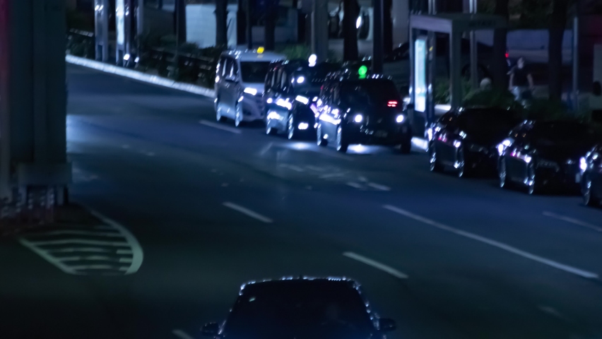 A night timelapse of the traffic jam at the urban street in Tokyo long shot zoom. High quality 4k footage. Minato district Roppongi Tokyo Japan 09.05.2022 Here is a city street in Tokyo