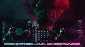 Dj plays music on party in night club, filme directly from above. 4k stock video of disc jockey playing set on stage