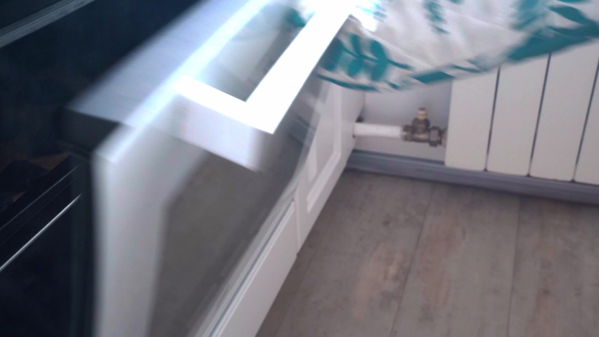 Hand taking out Christmas gingerbread cookies from open steaming kitchen oven. Preparing traditional Xmas and New Year pastry. Close-up of hot metal baking plate with burnt sweets and smoke.