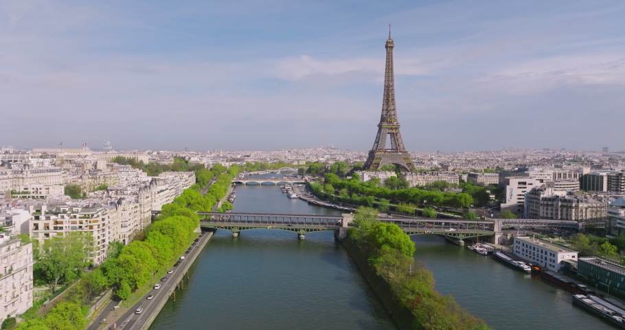 Aerial view of downtown Paris. A drone flies over the Seine River towards the Eiffel Tower. Green trees adorn the capital of France. Sunny day in Paris Royalty-Free Stock Footage #1096796299