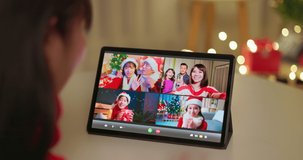 rear view asian woman use digital tablet on table to video chat with family and friend in christmas at home