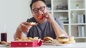 Fat asian man enjoy to eat junk food, hamburger, pizza, fried chicken - Powered by Shutterstock - Get 15% off with code: PIKWIZARD15