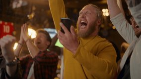 Excited Masculine Man Holding a Smartphone, Feeling Nervous About the Sports Bet He Put on a Favorite Soccer Team. Ecstatic When Football Team Scores a Goal and He Wins a High Stakes Casino Prize. - Powered by Shutterstock - Get 15% off with code: PIKWIZARD15