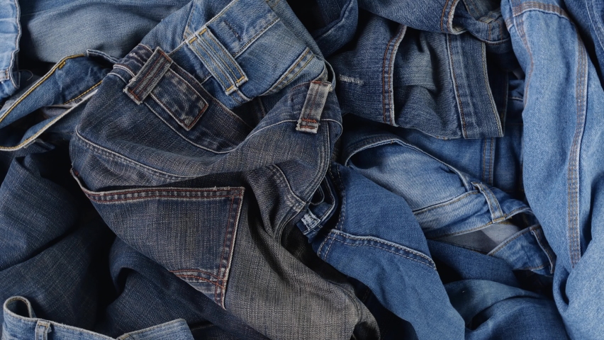 Old jeans. Blue cotton denim jeans. Quickly changing fashions, clothing waste Royalty-Free Stock Footage #1096803747