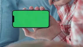 Man Using Smartphone in Vertical Mode with Green Mock-up Screen, Doing Swiping, Scrolling Gestures. Internet Social Networks Browsing News, Financial Reports In Phone. Vertical Video