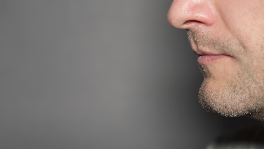 Close up speaking mouth. unshaven man talking mouth. side view of lower part young male face speaking, gray background, copy space. free space for text or logo. guy saying. speaking man mouth close up | Shutterstock HD Video #1096807381