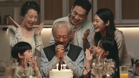 three generation asian family celebrating grandpa's birthday at home with cake and candle lights - Powered by Shutterstock - Get 15% off with code: PIKWIZARD15