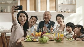 happy three generation asian family taking a selfie while eating meal at home - Powered by Shutterstock - Get 15% off with code: PIKWIZARD15