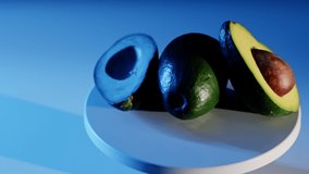 Up view Footage of sliced Avocados rotating on a dark blue background.