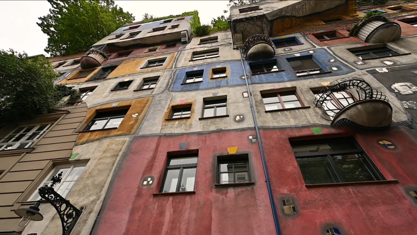 Vienna,Austria,August 2022. Beautiful panoramic footage of an iconic image with wide angle lens and low angle view of the colorful facade of the Hundertwasser house in Vienna. Residential condominium Royalty-Free Stock Footage #1096814911