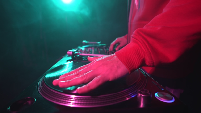 Hip hop dj scratching vinyl disc on turntables. Professional disc jockey scratches records on turn table in night club Royalty-Free Stock Footage #1096817955