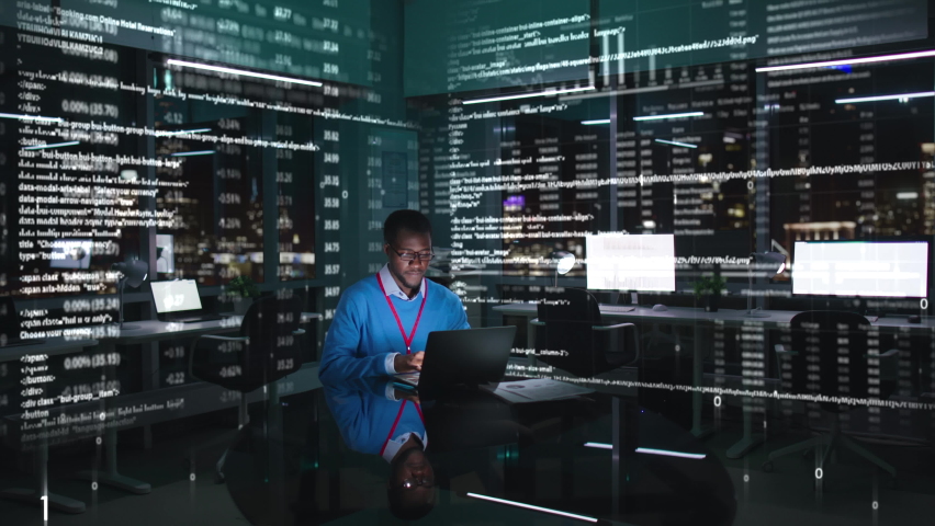 African-American programmer or broker working at computer in the data center with holograms. IT specialist work in office at night with holographic data in the air Royalty-Free Stock Footage #1096819161