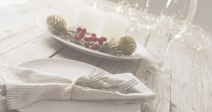 Animation of christmas greetings text over christmas place setting. Christmas, festivity, tradition and celebration concept digitally generated video.