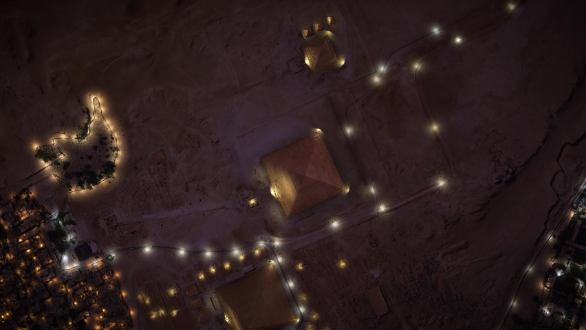 3D - Aerial top view of the Pyramids of Giza at dusk in Egypt. The three pyramids illuminated at night