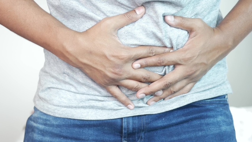 young man suffering stomach pain close up.
