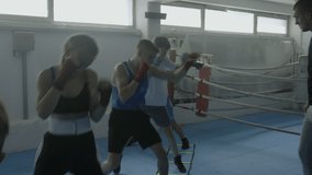Kids boxing class workout, teacher showing punches technique, teenagers group practicing kicks in gym. Boys and girls exercising, male boxer training children in combat sport club - Powered by Shutterstock - Get 15% off with code: PIKWIZARD15