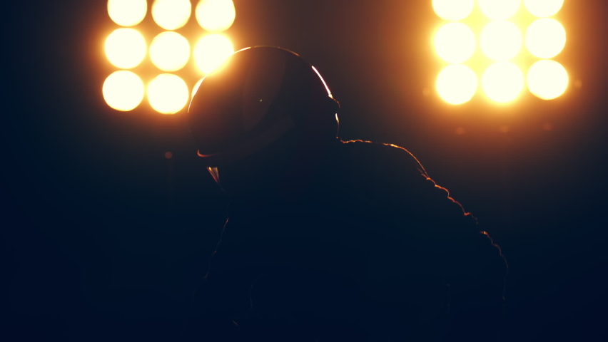 Silhouette of race car driver celebrating the win in a race against bright stadium lights. 100 FPS slow motion shot Royalty-Free Stock Footage #1096838299
