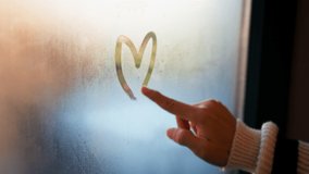B roll -  Finger of woman drawing a love heart shape symbol on wet glass of the window on a happy day at home. - Powered by Shutterstock - Get 15% off with code: PIKWIZARD15