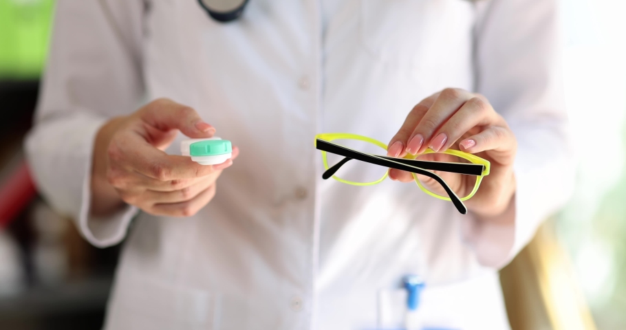 Doctor hands hold selection of glasses and contact lenses Royalty-Free Stock Footage #1096848621