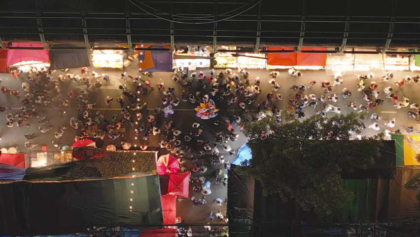 Aerial top view of amusement park in night temple fair, and night local markets. People walking street, Colorful tents in Bangkok city, Thailand. Retail shops