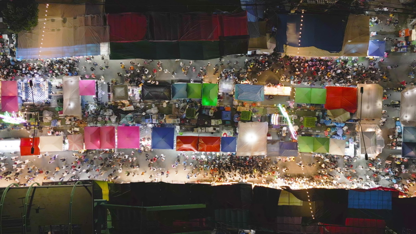 Aerial top view of amusement park in night temple fair, and night local markets. People walking street, Colorful tents in Bangkok city, Thailand. Retail shops