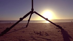 Camera on motion electronic slider stands on the beach at the sunset in slow motion 120fps