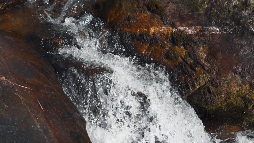 Slow motion shot of water stream in between the rocks at Manali in Himachal Pradesh, India. View of water flowing between the rocks after rainfall at Manali, Nature background.  | Shutterstock HD Video #1096858399