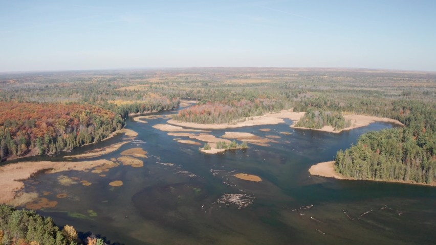 Au Sable River in Michigan during fall colors with drone video moving down.