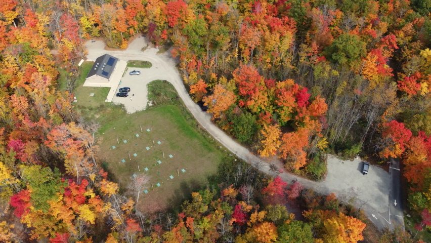 Majestic luxury mansion surrounded by colorful autumn forest, aerial drone view