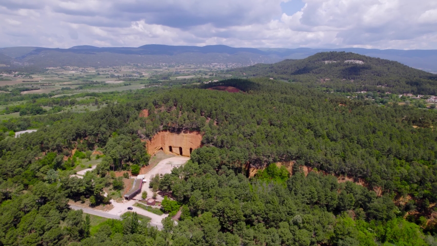 Aerial: far away panoramic shot of the amazing french landscape with one of the historic french mines inside the mountains view.