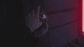 Vertical: A young guy takes a photo or video with a drone. The pilot controls the copter in the evening or at night. Travel blogger by car by nature. Adventures of man. Road trip, close up hands - Powered by Shutterstock - Get 15% off with code: PIKWIZARD15