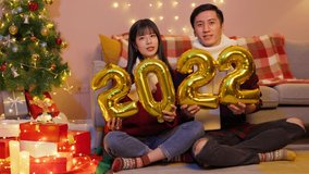 asian lovely young couple are congrating to friends for christmas with xmas video and ring in the New Year at home