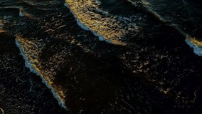 Dark sea water in autumn. Rocky coast of the Pacific Ocean, waves of sea water crashing on the rocks. Dramatic sunset nature.Drone flight over the sea