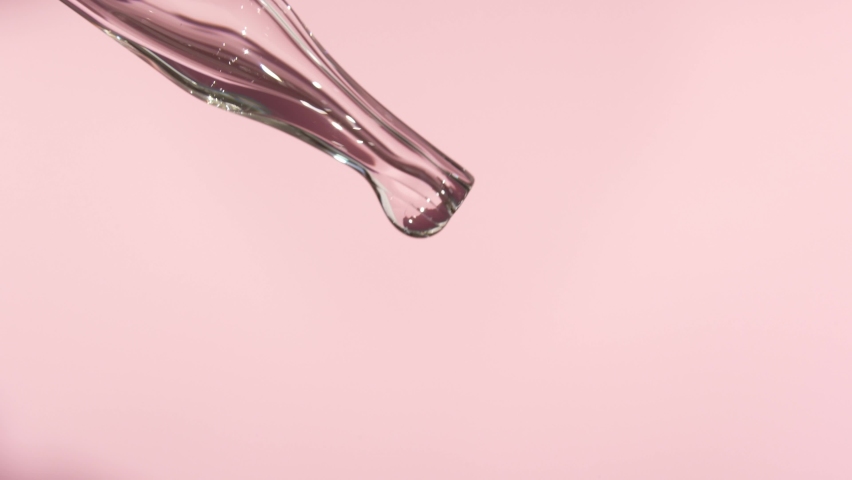 Pipette with liquid essence on a light pink background. Serum for the face. The concept of an extract for cosmetic purposes. High quality video Royalty-Free Stock Footage #1096874309