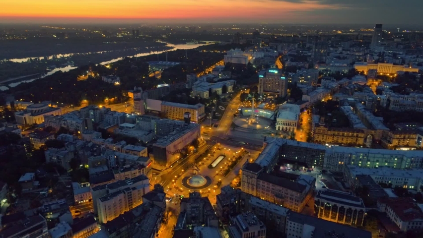 Night aerial view of Kyiv city center. Flying over Independence Square Maidan Nezalezhnosti in Kiev, Ukraine before sunrise. Red morning sky at background
