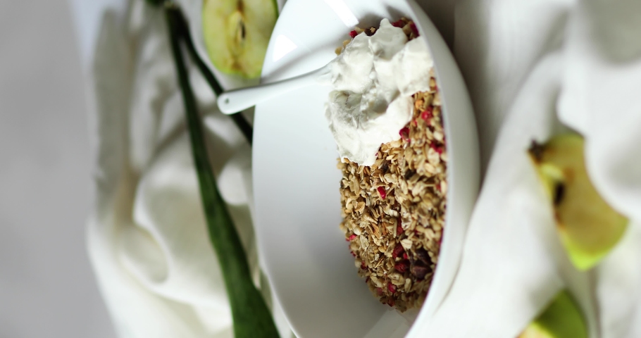 Vertical video rotation of morning granola breakfast with greek yougurt and glass of detox water with lemon, Homemade oatmeal granola, healthy food.