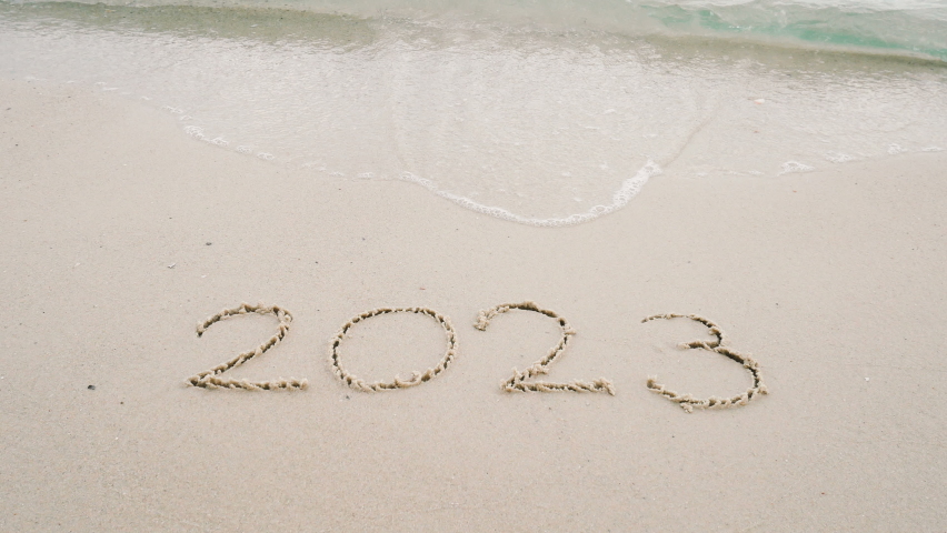 4K happy new year 2023. number 2022 write on sandy beach, ocean wave splash change to 2023. countdown for happy new year turning from year 2022 to 2023 video footage background | Shutterstock HD Video #1096880383
