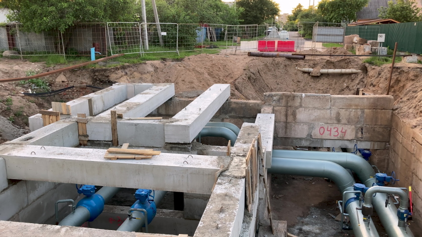 Laying hot water pipes right in the middle of the road. A pit has been created on the road for carrying new plumbing pipes. Underground pipeline repair.
