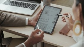 Close up shot of male and female colleagues discussing financial data on digital tablet while working together on business plan in office - Powered by Shutterstock - Get 15% off with code: PIKWIZARD15