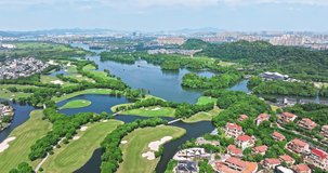 Aerial footage of green golf course and beautiful river with modern city skyline natural scenery in Shao Xing, Zhejiang, China.