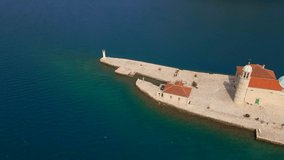Aerial video. The temple of the Our Lady of the Rocks which is located on the man-made island in the Bay of Kotor. Travel to Montenegro concept. Slowmotion