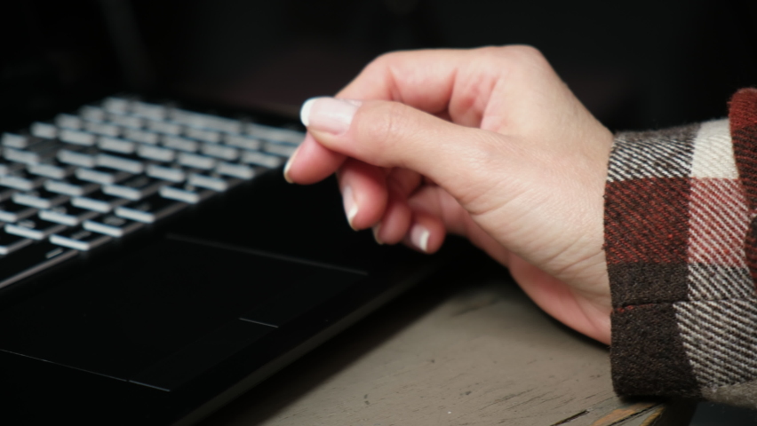 A woman's hand making zoom-in and double-click motions on a black laptop touch-pad from close-up view Royalty-Free Stock Footage #1096888721