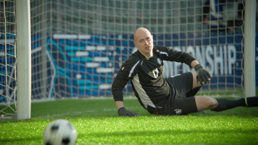 Professional Soccer Football Match Championship: Goalkeeper Catches the Ball Professionaly, Saving the Gates. Sport Channel Broadcast Television, Tracking Playback in Slow Motion - Powered by Shutterstock - Get 15% off with code: PIKWIZARD15