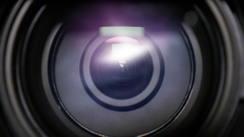 A close up view of a telescope or camera lens photographing a distant spiral galaxy in space. Camera zooms as the night sky comes into focus. Composited.	