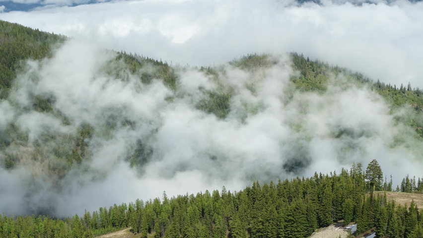 Aerial above two person chairlift in summer in Sierra Nevadas on Donner Pass, California with snowy peak in background