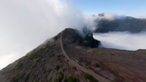 Стоковое видео: FPV Drone View of Pico de Areiro over the clouds during sunrise