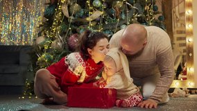 Family and sweet little asian baby boy at decorated fir-tree open box with surprise of Christmas. Happy mom dad unpack present or gift. Merry Christmas, happy new year loving parents concept - Powered by Shutterstock - Get 15% off with code: PIKWIZARD15