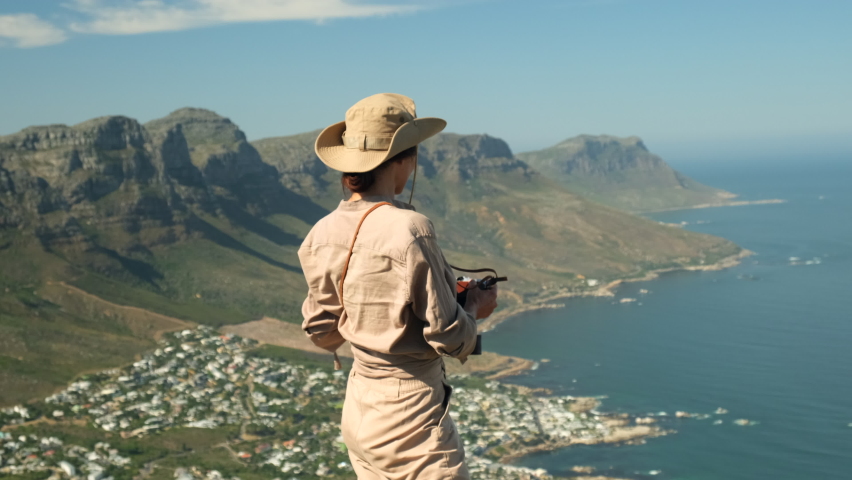 woman tourist takes a photo high in the mountains. Table Mountain and 12 Apostles from Lion